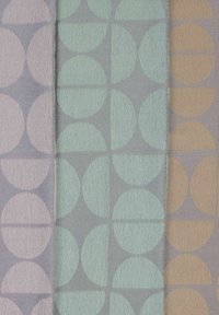 Three vertical fabric panels with repeating geometric patterns of half and full circles in pastel pink, mint green, and light brown on gray.