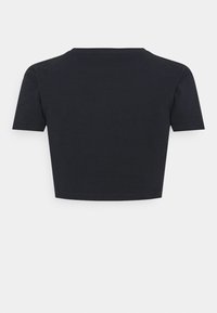 T-shirt noir court en coton doux. Doté de manches courtes et d'un col rond, avec un design épuré et minimaliste.