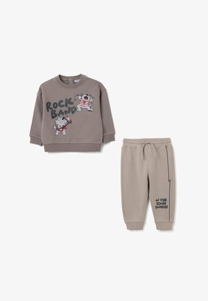 Bruine sweatshirt met cartoon-rockbandontwerp; bijpassende beige sweatpants met de tekst "VANAVOND OP HET PODIUM". Zachte stof, relaxte pasvorm.
