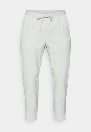 Αθλητικό παντελόνι ανοιχτό γκρι με ελαστική μέση, ρυθμιζόμενο κορδόνι και στενή γραμμή. Διαθέτει ραφές διακόσμησης και λογότυπα.