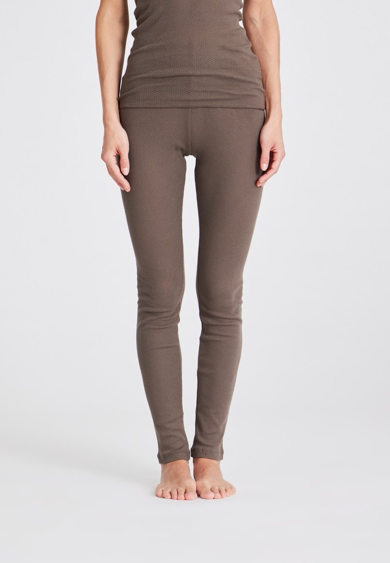 Braune, enganliegende Leggings aus strukturiertem Stoff, mit einem hohen Bund und einer glatten Verarbeitung, die sich zu den Knöcheln verjüngen.