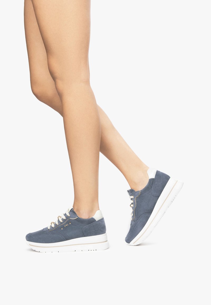 Baskets en daim bleu avec semelle blanche, bout rond, œillets dorés et accents contrastants au talon. Les chaussures ont une texture lisse et une fermeture à lacets.