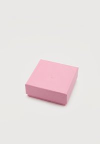 Μικρό κλειστό ροζ κουτί κοσμημάτων σε σχήμα τετραγώνου με διακριτικό υφασμένο σχέδιο και ανάγλυφο λογότυπο κύκνου στην κορυφή, σε λευκό φόντο.
