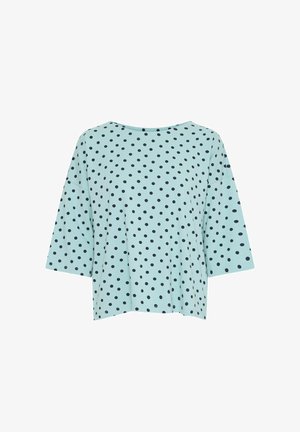 Hele sinine lühikeste varrukatega pluus, millel on mustad täpid, lahtine lõige ja lai kaelus. Sile kangas, millel on peen tekstuur.