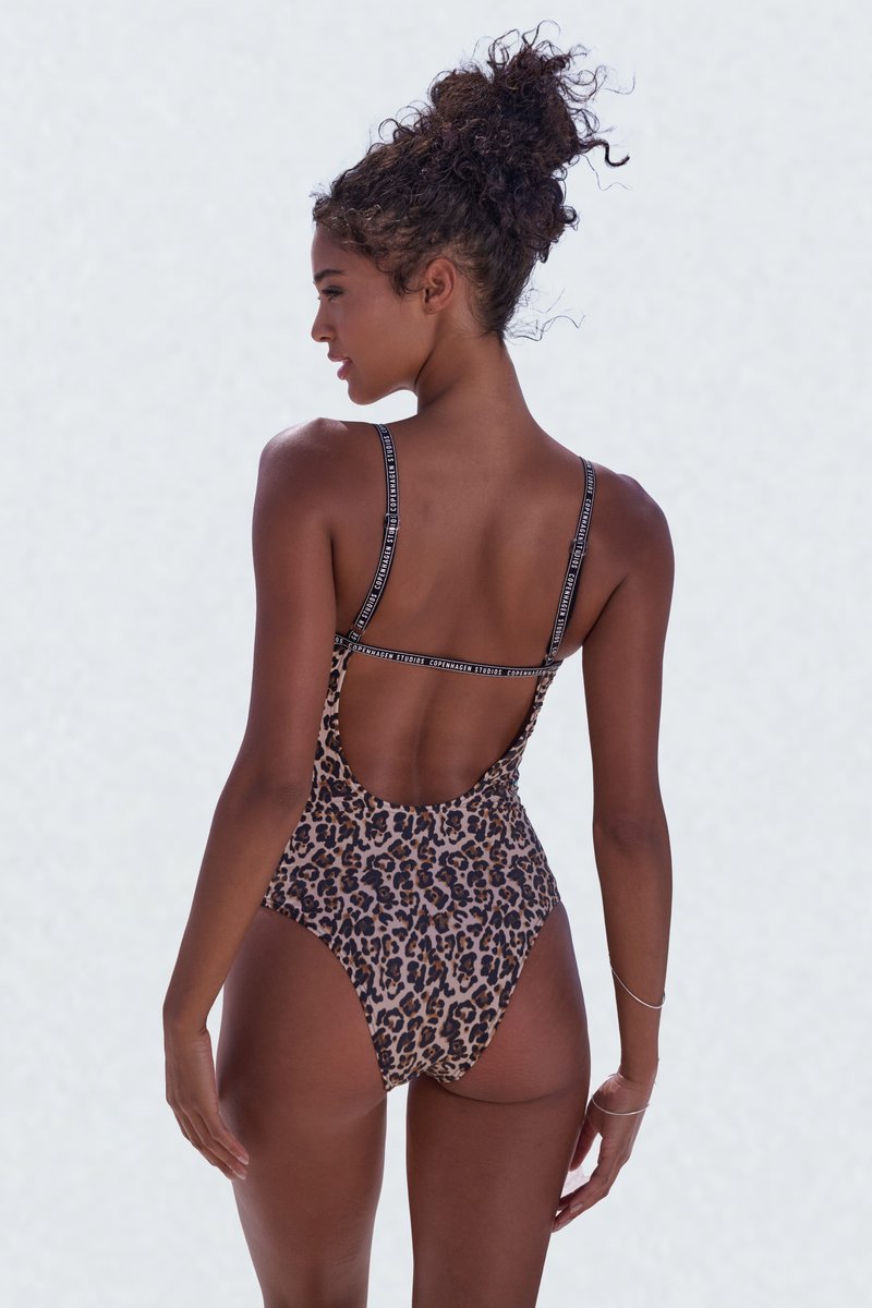 Ein einteiliger Badeanzug mit Leopardenmuster, dünnen schwarzen Trägern und tiefem Rückenausschnitt. Glatte Textur und lebendige Farben; verfügt über einen runden Halsausschnitt.