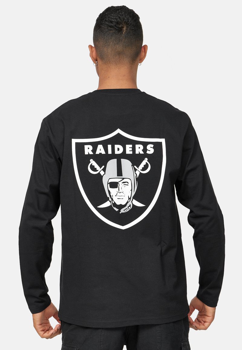 Svart långärmad t-shirt med en stor vit Raiders-logotyp på baksidan, inklusive en styliserad hjälm och korslagda svärd.