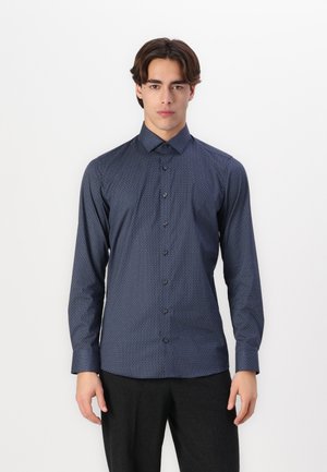 Chemise à manches longues bleu marine avec un motif géométrique subtil, fermeture boutonnée à l'avant et col; fabriquée dans un tissu lisse.
