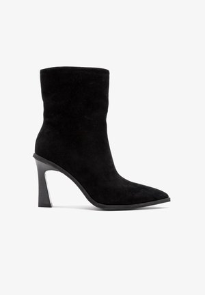 Schwarze Wildleder-Stiefelette mit spitzer Zehenform und hohem Stiletto-Absatz. Glatte Oberfläche mit zylindrischem Absatzdesign und ohne sichtbare Beschläge.