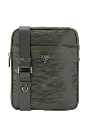 Sac bandoulière vert olive texturé avec sangle ajustable et logo triangulaire Guess au centre devant.