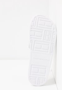 Sole di infradito in gomma bianca con un motivo di presa testurizzato. "TOMMY HILFIGER" è impresso sul lato. Design sagomato per il comfort.