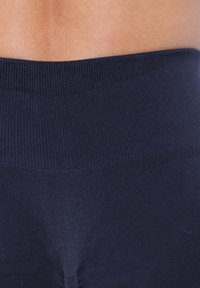 Marineblauwe naadloze tailleband van leggings; tekstuur met ribbels zichtbaar aan de bovenkant, met een gladde stof die overgaat naar het onderste gedeelte.