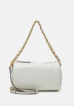 Sac à main cylindrique en cuir blanc avec une bandoulière chaîne en or et cuir et une bandoulière épaule en cuir amovible sur fond clair.