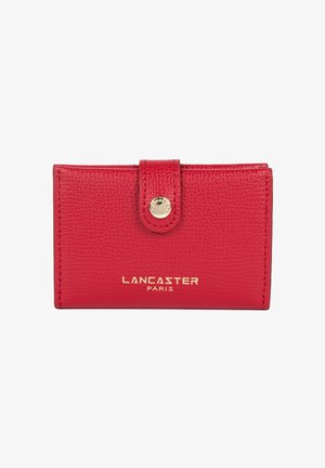 Portacarte in pelle rossa con texture, chiusura a bottone automatico dorato e logo "LANCASTER PARIS" in rilievo sul davanti. Forma rettangolare compatta.