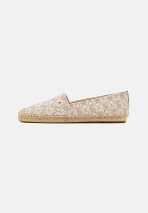 Espadrille slip-on sko i lys beige stoff med et subtilt mønster, en vevd jute såle, og en gullfarget logoaksent på overdelen.