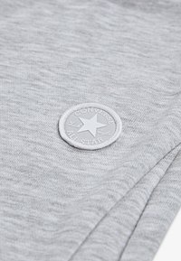 Γκρίζο ύφασμα φούτερ με απαλή υφή, που διαθέτει λευκό, κυκλικό, ανάγλυφο λογότυπο Converse All Star με σχέδιο αστεριού.