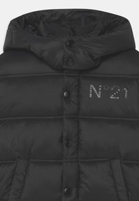 Černá puffer vesta s vysokým límcem, předními patentkami, prošívanou texturou a šedým logem potištěným na hrudi.