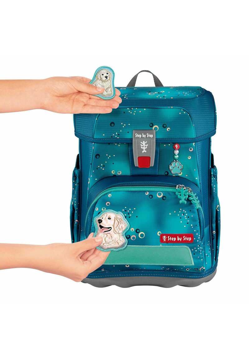 Teal backpack with a patterned design; features a gray base, red hardware, and removable animal patches. Accents include decorative beads.