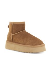 Stivale alla caviglia in suede marrone con una spessa suola di piattaforma beige e punta arrotondata, progettato per un uso casual e per il comfort invernale.