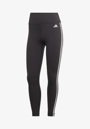 Svarta leggings i ett elastiskt material med hög midja. Har vita sidstreck och en Adidas-logotyp nära midjan.