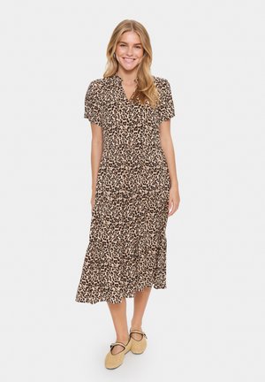 Abito midi con stampa leopardata, maniche corte, colletto a punte e gonna a strati. Realizzato in tessuto leggero, abbinato a calzature beige.