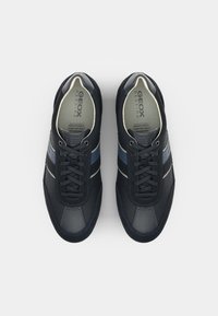 Sötétkék sportcipők bőr és textil felsőrésszel, hálós részletekkel, lapos fűzőkkel, légáteresztő talppal és diszkrét csíkozással.