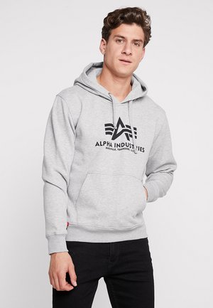Grå hoodie lavet af en bomuldsblanding, med en front kangaroo lomme, snoretræk i hætten og et sort logo print på brystet.