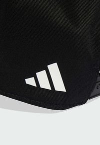 Gorra negra con un tejido texturizado y un prominente logotipo de tres rayas blancas en el lateral, con un visera curva y correa ajustable.