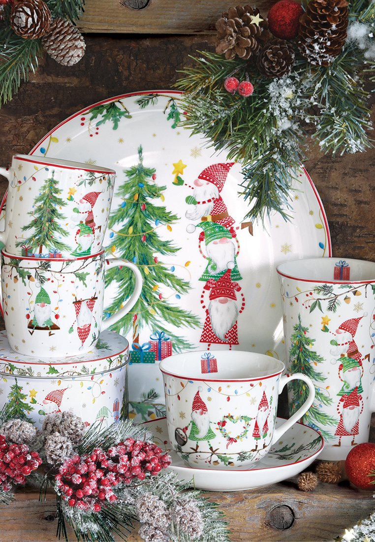 Set da tè in ceramica con design di gnomi festivi, caratterizzato da accenti rossi e verdi, alberi di Natale e elementi decorativi, impilato su un piatto festivo.