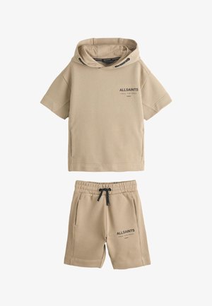 Completo beige con felpa con cappuccio a maniche corte e pantaloncini abbinati con "ALLSAINTS" e testo giapponese stampati su entrambi i pezzi.