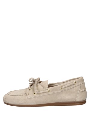 Beige suède mocassin loafer met veters, gouden oogringen en een platte bruine zool, zijaanzicht.