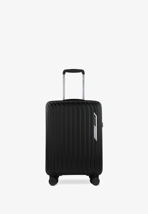 Valise rigide noire avec un design à rainures verticales, poignée argentée, système de trolley rétractable, quatre roulettes noires et accent de logo sur le côté.
