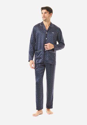 Conjunto de pijama azul marino con lunares blancos, camisa de botones de manga larga, pantalones a juego y ribete blanco en el cuello y los bolsillos.