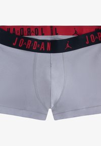 Boxer briefs grigi con una fascia elastica nera che presenta il testo e il logo "JORDAN" in rosso. Tessuto liscio con dettagli di cuciture visibili.