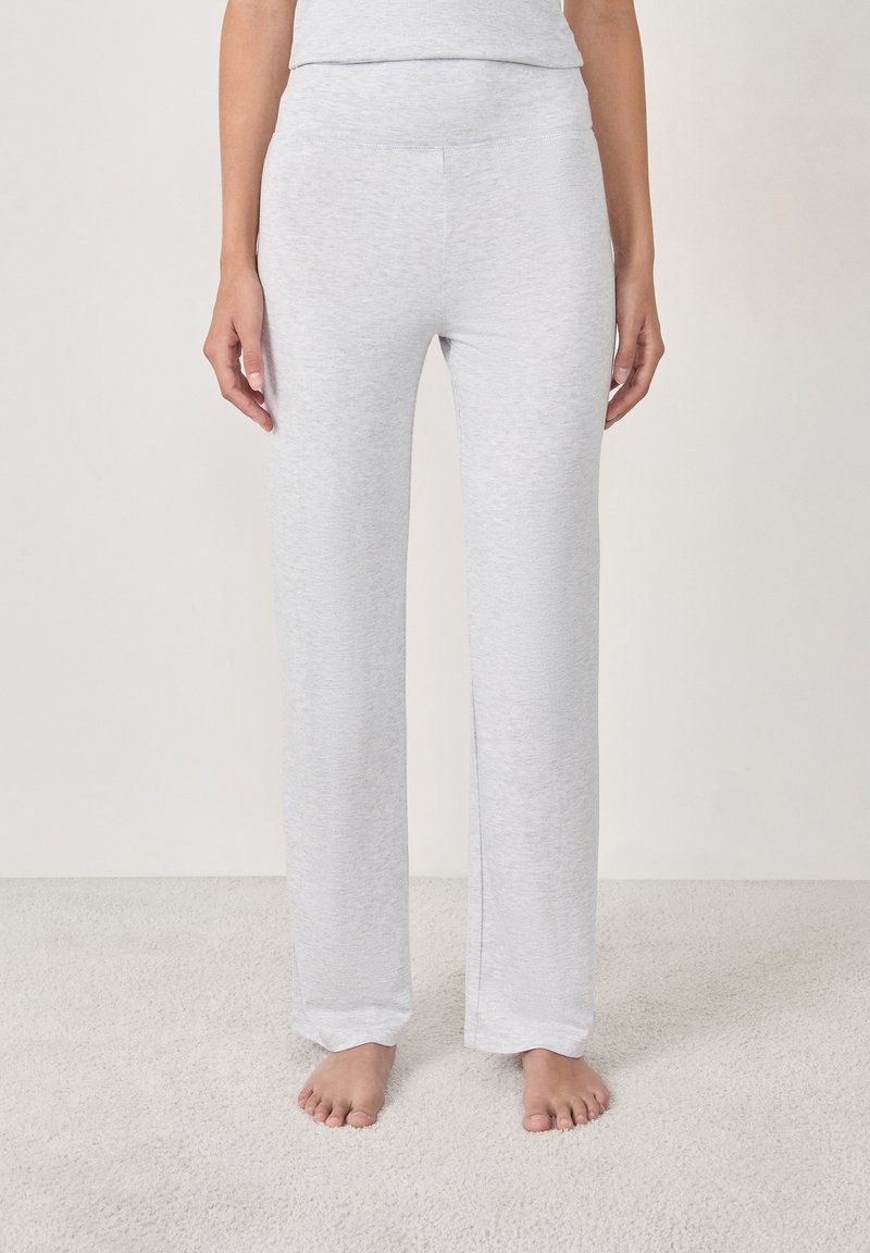 Lichtgrijze loungebroek gemaakt van zachte, elastische stof. Kenmerkt zich door een brede tailleband en een rechte pijp, zonder zichtbare patronen of accenten.