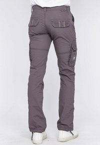 Pantalon cargo gris avec poches latérales et arrière, fabriqué en tissu léger, offrant une coupe décontractée et des poignets élastiques aux chevilles.