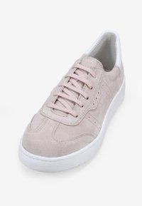 Zapatillas de ante en rosa claro con una suela de goma blanca. Presentan un diseño clásico de cordones y detalles de costura sutiles.