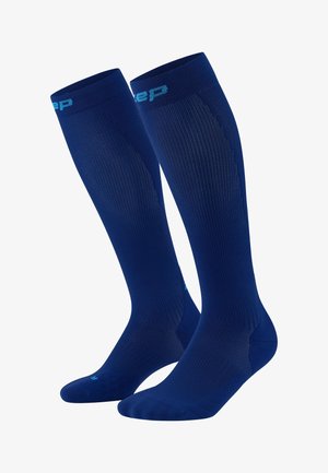 Blue knee-high compression socks with ribbed texture, smooth finish, and contrasting light blue logo at the top.