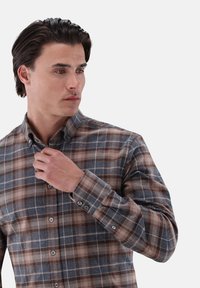 Braun und blau karierter Hemd aus einem Stoff mit weicher Textur, mit einem Button-Down-Kragen und langen Ärmeln mit geknöpften Manschetten.