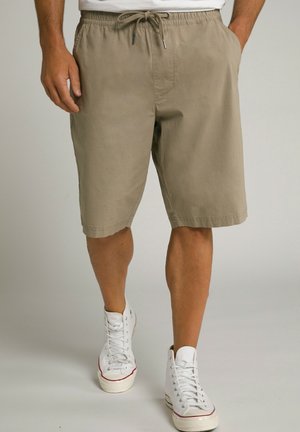 Beige, knielange Shorts mit elasticem Bund und Kordelzug. Verfügt über Seitentaschen und einen glatten, leichten Stoff. Getragen mit weißen Sneakers.