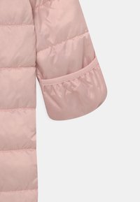 Lichtroze donsjackmouw met een glanzende afwerking, voorzien van doorgestikte secties, elastische manchetten en een gladde textuur.