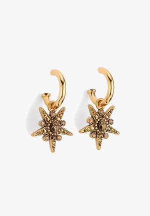 Goudkleurige oorbellen in de vorm van hoepels met een stervormig ontwerp, intricaten details, zwarte accenten en kleine embellissementen van rhinestone.