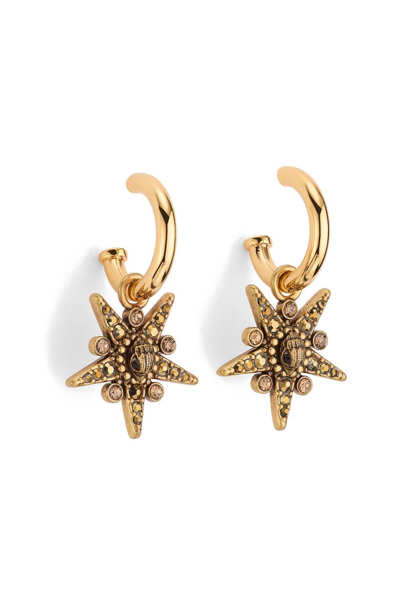 Boucles d'oreilles en métal doré en forme de créoles, présentant un design en étoile avec des détails élaborés, des accents noirs et de petites embellissements en strass.