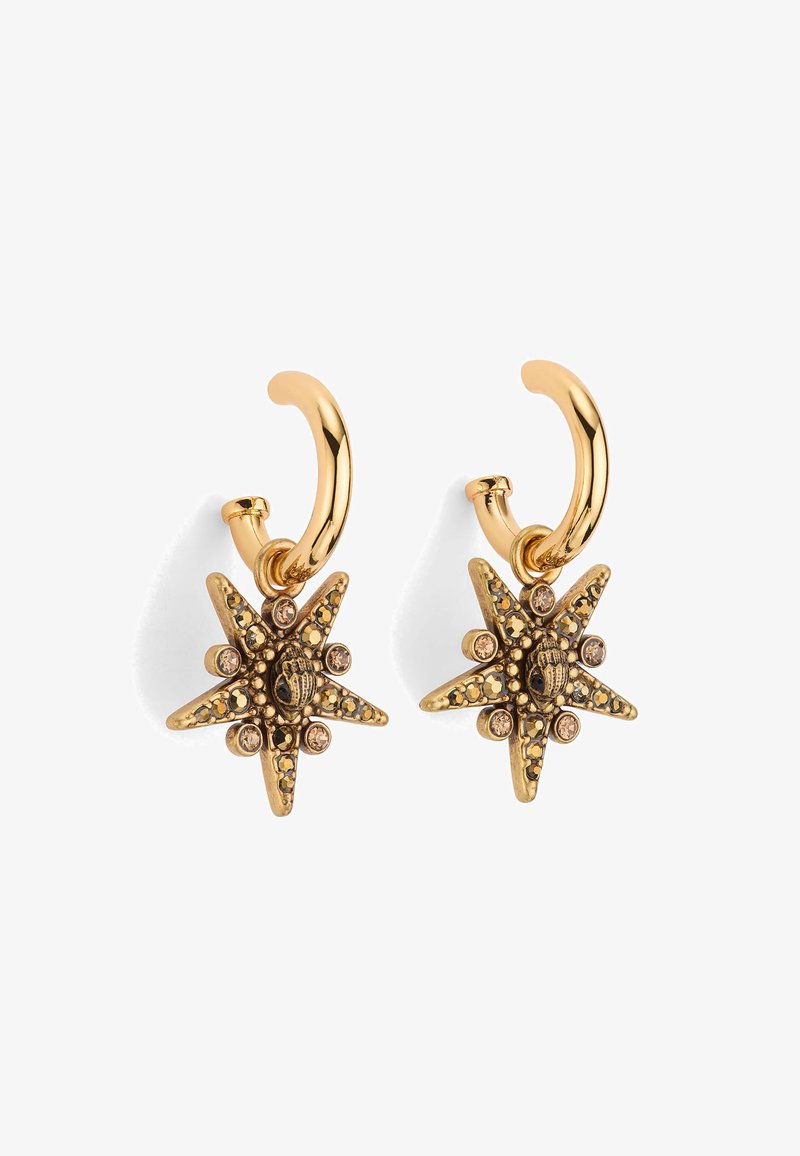Boucles d'oreilles en métal doré en forme de créoles, présentant un design en étoile avec des détails élaborés, des accents noirs et de petites embellissements en strass.