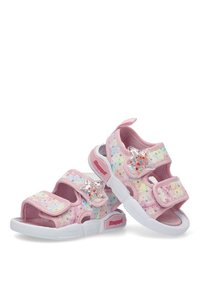 Sandalias rosas con un acento en forma de estrella, con parte superior de tela suave, correas ajustables y una suela de goma blanca. Patrón de brillo incluido.