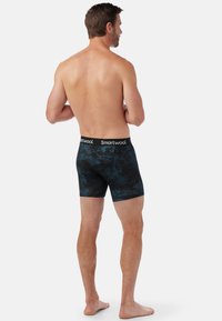 Boxer briefs a fantasia blu e nera con una morbida fascia in vita, realizzati in tessuto di lana, caratterizzati da un design aderente e una lunghezza fino a metà coscia.
