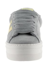 Sneaker grigio in suede con superficie testurizzata, suola spessa bianca, lacci elasticizzati e un accento giallo sul lato.