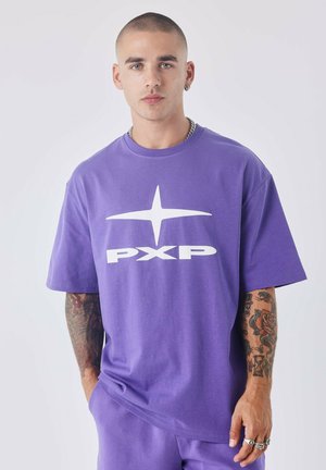 T-shirt en coton violet avec un grand logo "PXP" blanc et un graphique d'étoile sur le devant. Manches courtes et coupe décontractée.