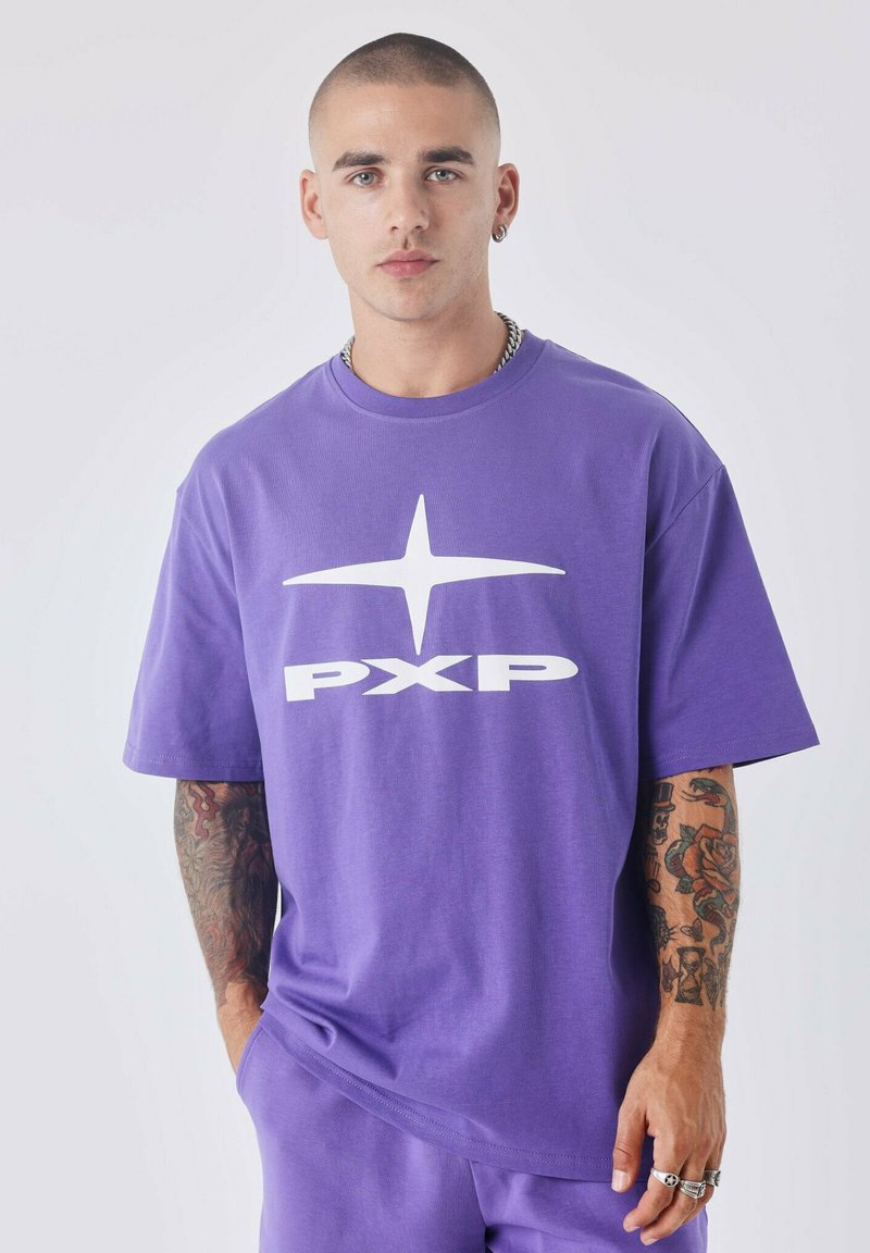 T-shirt en coton violet avec un grand logo "PXP" blanc et un graphique d'étoile sur le devant. Manches courtes et coupe décontractée.