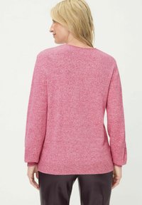 Rosa Pullover mit strukturiertem Strickmuster, langen Ärmeln und rundem Ausschnitt. Dezente, gerippte Akzente an Bündchen und Saum verleihen dem Design eine besondere Note.