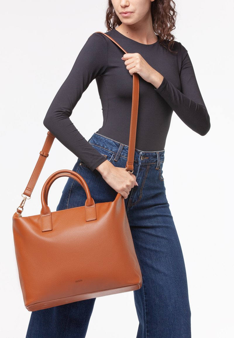 Borsa a tracolla in pelle marrone con doppi manici e una lunga tracolla regolabile. Superficie testurizzata, forma rettangolare e branding minimale sul davanti.